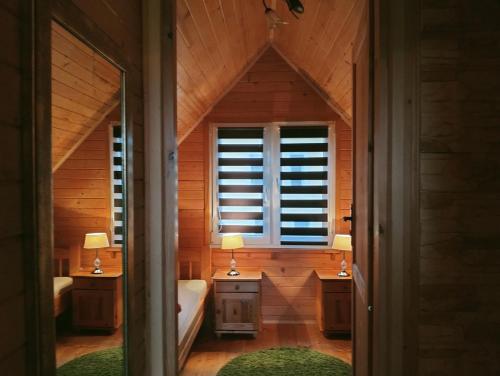 a bathroom with two sinks and a tub and a window at Bajkowe Domki in Polańczyk