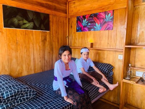 a woman and a child sitting on a bed at Buahan Sweet Glamping ( BSG) in Kubupenlokan