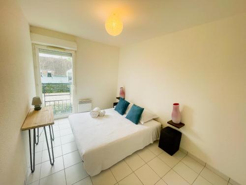 Un dormitorio con una cama grande y una ventana en Appartement en Résidence avec Piscine, en Coulounieix-Chamiers