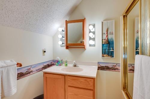 a bathroom with a sink and a mirror at Riverfront Au Gres Cottage with Fire Pit and Grill! in Au Gres