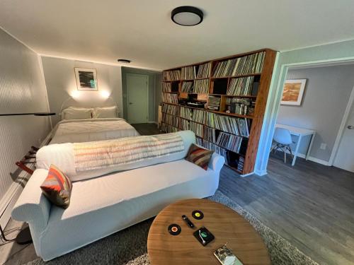 a bedroom with a bed and a couch and a book shelf at Mid-Century DJs Dream near Rhinebeck 