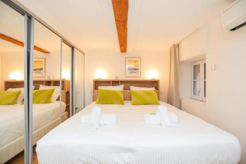 - une chambre avec 2 lits dotés d'oreillers jaunes et verts dans l'établissement IMMOGROOM - Beautiful Duplex - 5 min from the beach - AC - SUQUET, à Cannes