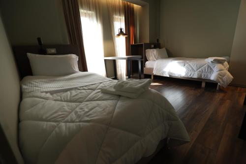 a bedroom with two beds and a window at Vila Borgjeze in Korçë