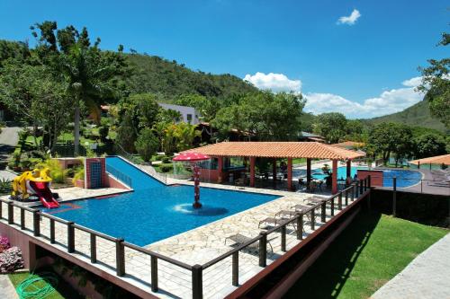 a resort with a swimming pool with a bridge at Pousada do Rio Turvo in Capitólio