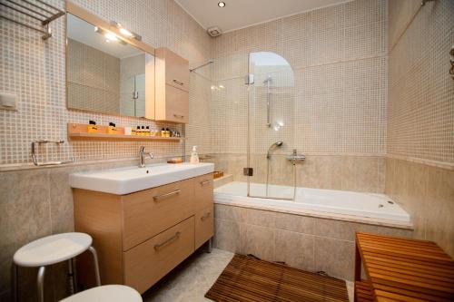 a bathroom with a sink and a tub and a toilet at ZeusPlace Fenia’s Nest House in Litochoro