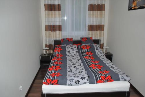 a bed with black and red blankets and pillows at Apartament Zwyciezcow in Polanica-Zdrój
