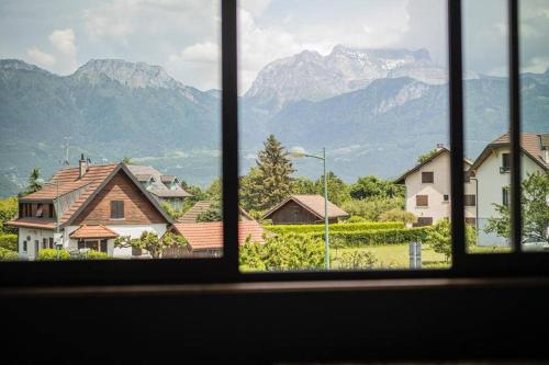uma vista a partir de uma janela de casas e montanhas em Venez Chez Vous - La Grange du Lac - Vue montagne em Saint-Jorioz