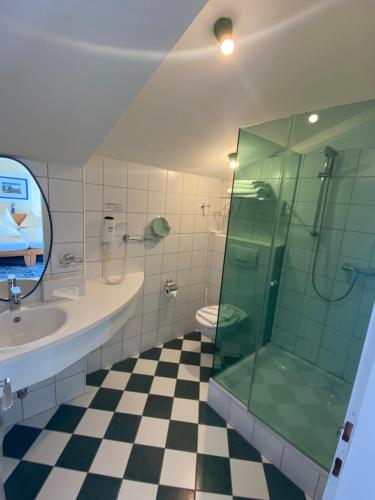 a bathroom with a glass shower and a sink at Hotel Seewirt in Maria Wörth