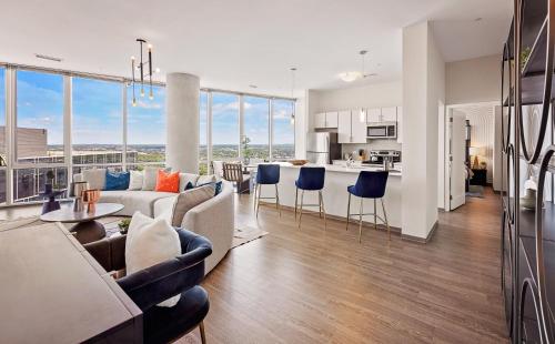 a living room and kitchen with a couch and chairs at Placemakr Premier SoBro in Nashville