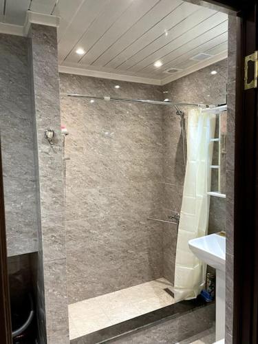uma casa de banho com um chuveiro e um lavatório. em Aram Guest House em Sevan