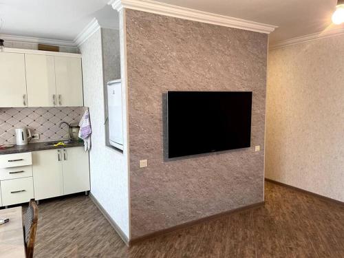 uma sala de estar com uma televisão de ecrã plano na parede em Aram Guest House em Sevan