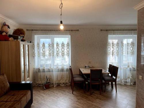 ein Wohnzimmer mit einem Tisch, Stühlen und Fenstern in der Unterkunft Aram Guest House in Sewan