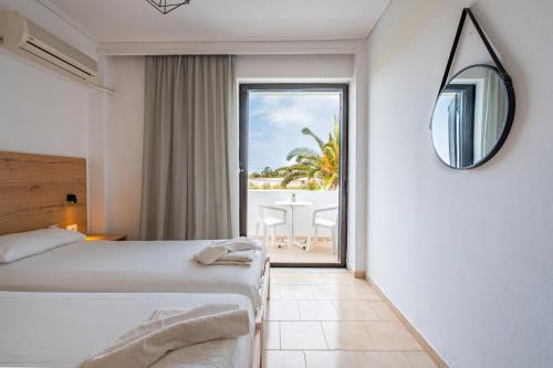 マルマリにあるAnthia Apartmentsのベッド付きのホテルルームで、海の景色を望めます。