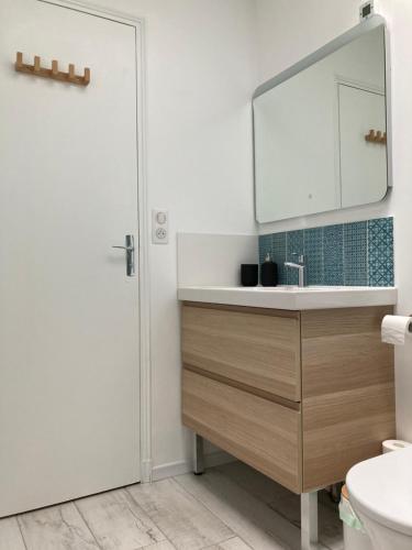 une salle de bain avec un lavabo et un miroir dans l'établissement Chambre indépendante 10min circuit 24h tramway, au Mans