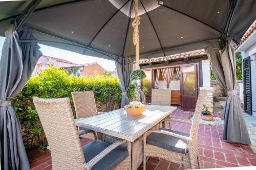 a table and chairs under an umbrella on a patio at Guesthouse Istra Premantura in Premantura