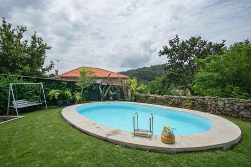 a swimming pool with a chair in a yard at AlmadeMencía in Pontevedra