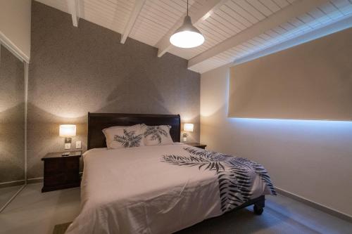 een slaapkamer met een bed en een nachtkastje met 2 lampen bij CASA Arte- Exclusive apartment with internet and pool in Santa Catharina