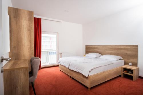 a bedroom with a bed and a chair and a window at Kašmir in Bugojno