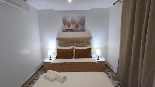 a bedroom with a large bed with two lamps on tables at DLX02 - Appartement Deluxe 2 chambres - Centre Ville Oujda in Oujda