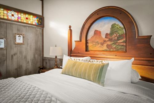 1 dormitorio con cama blanca y cabecero de madera en Adobe Village Inn, en Sedona