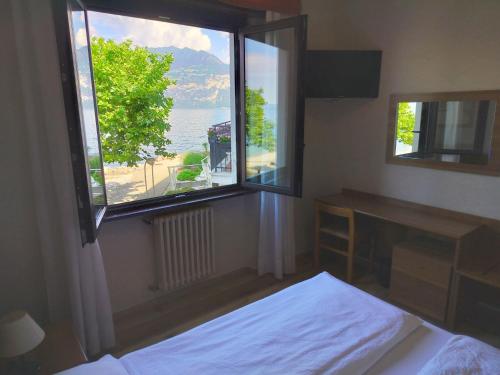 a bedroom with a window with a view of the ocean at Hotel S.Maria in Brenzone sul Garda