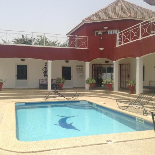a swimming pool in front of a house with a shark painted on it at Le Paradis in Nianing