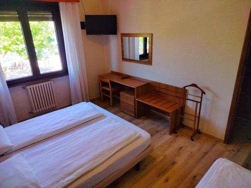 a bedroom with two beds and a desk and a mirror at Hotel S.Maria in Brenzone sul Garda