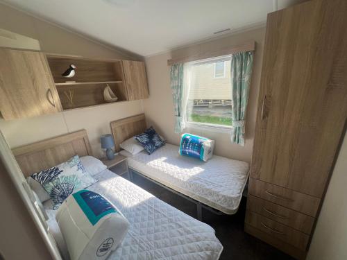 a small bedroom with two beds and a window at 170 Newquay Bay Resort in Porth