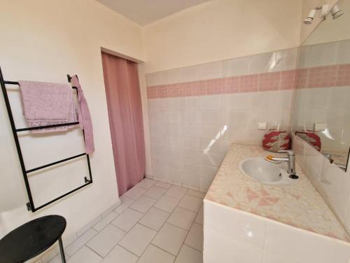 ein weißes Badezimmer mit einem Waschbecken und einer Theke in der Unterkunft Le Paradis in Nianing
