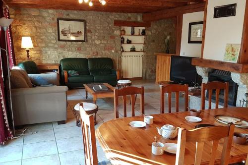 een woonkamer met een tafel en een bank bij Lozère St Alban Aubrac Margeride gîte 4 étoiles 8 personnes au calme près nature in Saint-Alban-sur-Limagnole