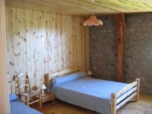 1 dormitorio con 1 cama y pared de madera en Lozère St Alban Aubrac Margeride gîte 4 étoiles 8 personnes au calme près nature en Saint-Alban-sur-Limagnole