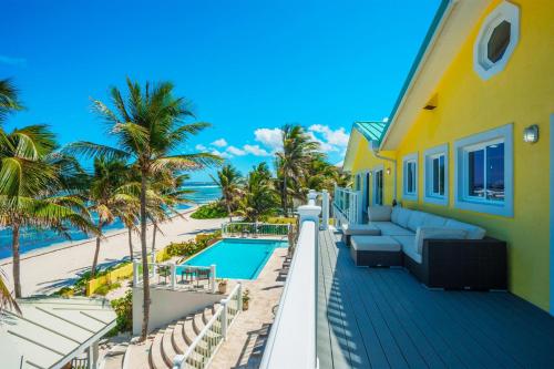 a view of the beach from the balcony of a house at Fischers Reef by Grand Cayman Villas & Condos in Driftwood Village