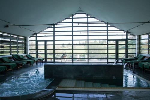 Cette grande chambre dispose d'une grande baignoire avec des chaises vertes. dans l'établissement Gîte au calme près nature Aubrac Margeride 3 étoiles, à Saint-Alban-sur-Limagnole