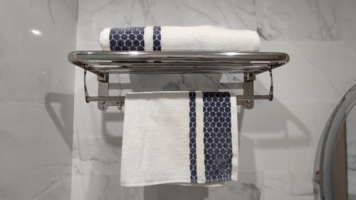 a towel rack with towels on it in a bathroom at DLX02 - Appartement Deluxe 2 chambres - Centre Ville Oujda in Oujda