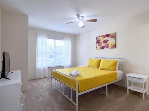 1 dormitorio con 1 cama con manta amarilla en 4 Bedroom Town Home Near Disney townhouse en Kissimmee