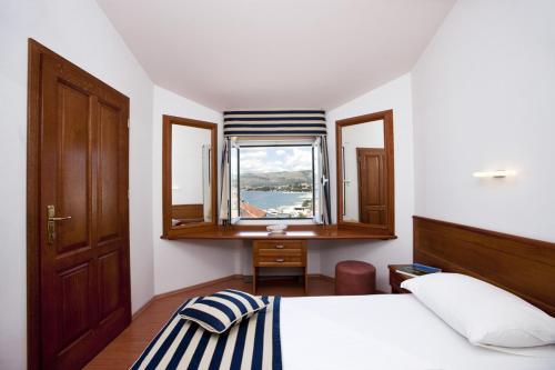 1 dormitorio con cama, escritorio y ventana en Villa Kruna Grada, en Trogir