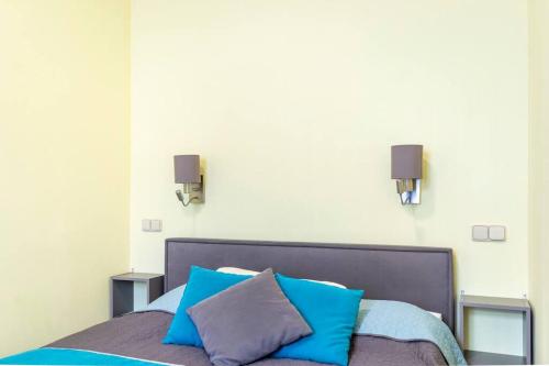 un lit avec des oreillers bleus et gris dessus dans l'établissement Apartment Becherhaus, à Karlovy Vary