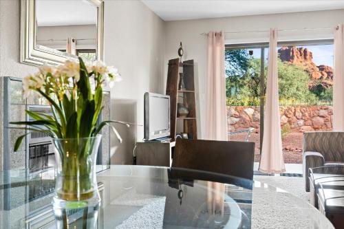 a living room with a glass table with flowers on it at 100 Bell Rock Condo- Supai condo in Sedona