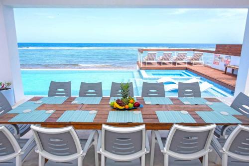 a table and chairs with a view of the ocean at Present Moment by Grand Cayman Villas & Condos in Bodden Town