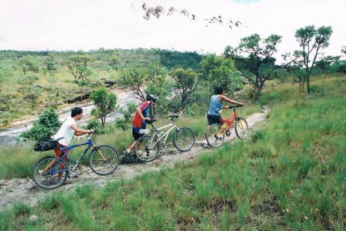 tre persone in bicicletta su un sentiero sterrato di Cataguás Brasil Pousada a Carrancas