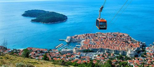 a gondola flying over a city on the water at Hidden Gem above Dubrovnik in Dubrovnik