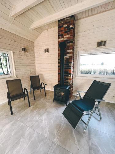 a room with two chairs and a wood stove at U Progu Lasu in Budy