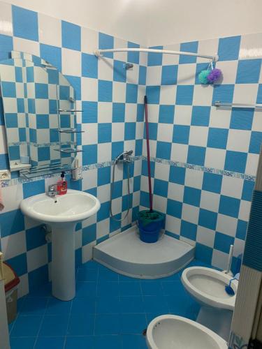 uma casa de banho azul e branca com um lavatório e um WC em Endri em Golem