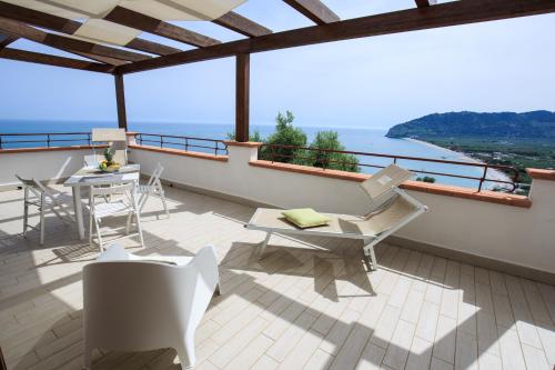 a balcony with a table and chairs and the ocean at Holiday Lodge al Porto in Mattinata