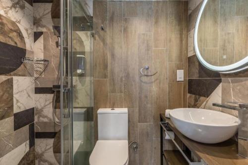 bagno con servizi igienici, lavandino e specchio di Private studio room 13 at OLO Living nestled in St Julians a Paceville