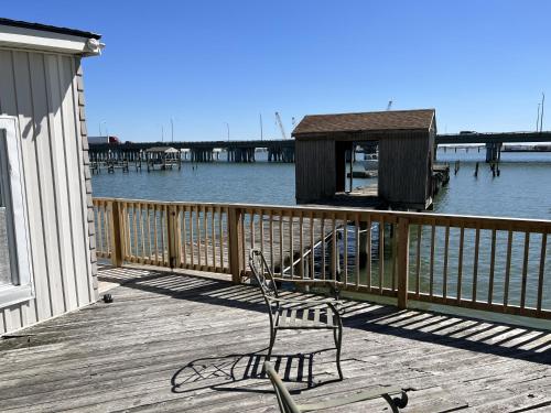 a bench sitting on a deck next to the water at Boat House Studio - Water Front Pets WiFi Smart TV apts in Norfolk