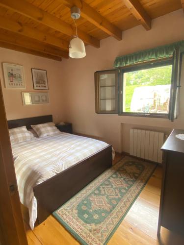 a bedroom with a bed and a window and a rug at CASA LUISA Biedes, Piloña in Infiesto