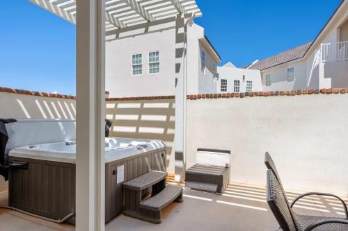 a patio with a hot tub and chairs at Highlander townhouse in Hurricane