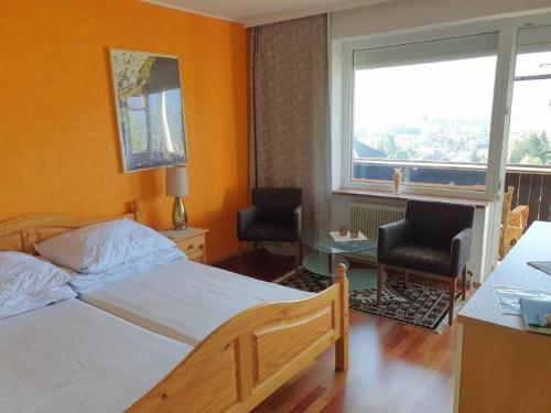 1 dormitorio con 1 cama, 2 sillas y ventana en Alpenurlaub II Wohnung mit Traumausblick, en Bad Mitterndorf