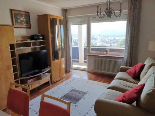 ein Wohnzimmer mit einem Sofa und einem großen Fenster in der Unterkunft Alpenurlaub II Wohnung mit Traumausblick in Bad Mitterndorf